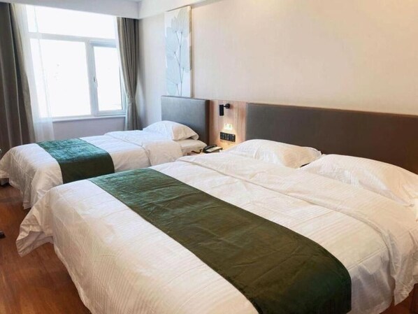 A hotel room with two beds, a bedside table with a lamp, a window with curtains, and a wall-mounted light fixture. - Greentree Inn Beijing Fangshan District Doudian Road Jinxin Yuan Express Hotel (Fangshan)