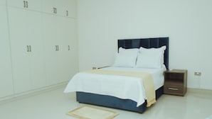 Une chambre à coucher comprenant un lit, une table de chevet, une armoire et une petite table.
