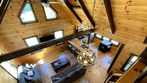 A spacious loft-style room with a large sofa, a dining area, and a kitchen.