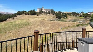 Vista d'una església a la part alta d'un turó, amb una zona tancada al primer pla.