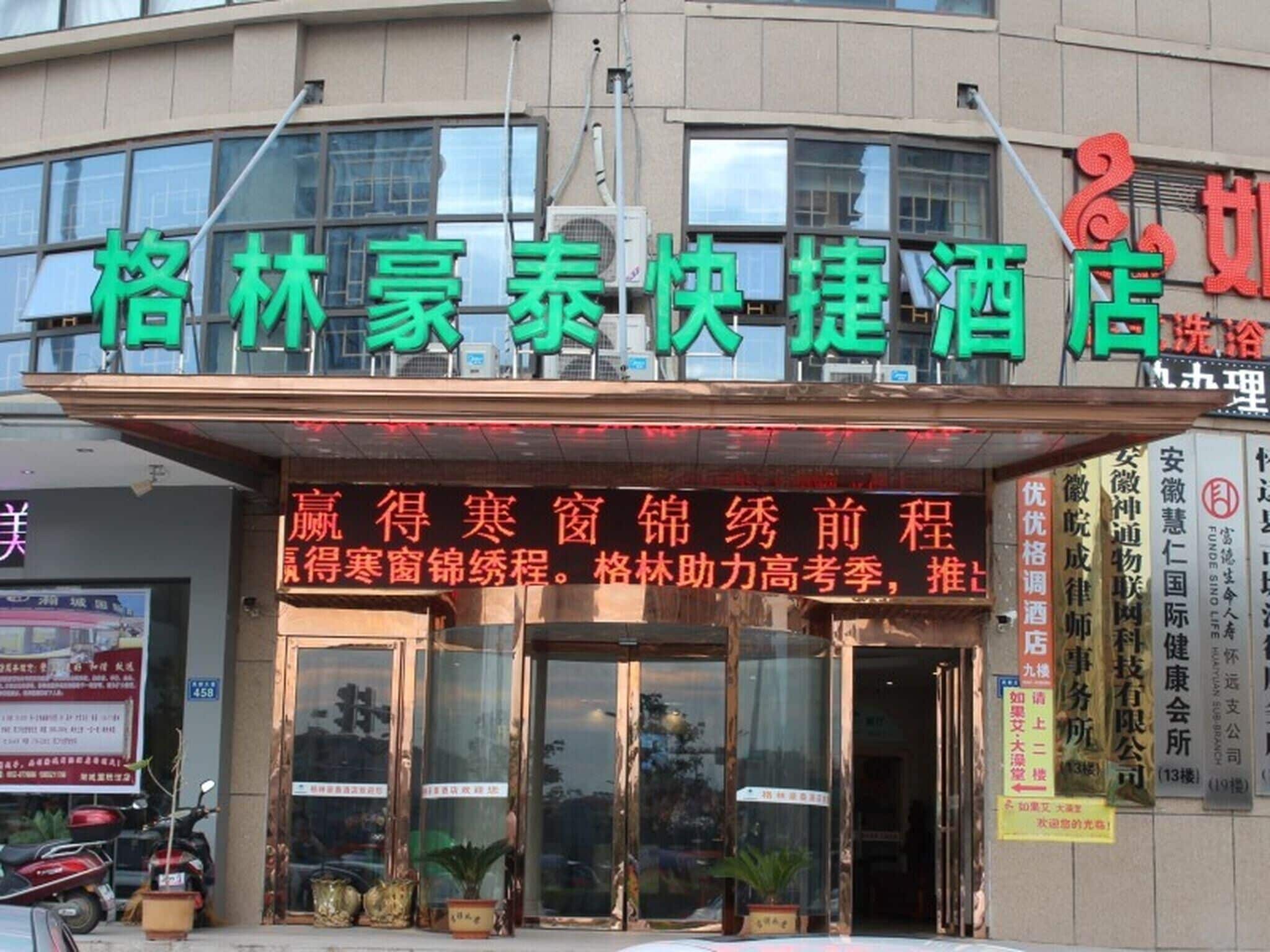 A hotel with a prominent signboard displaying its name and services.