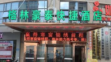 A hotel with a prominent signboard displaying its name and services.