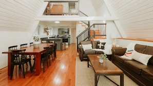 Un loft spacieux comprenant un coin repas, une cuisine et un salon.