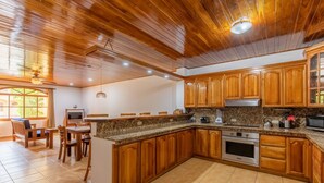 Un'ampia cucina con mobili in legno, piani in granito e elettrodomestici in acciaio inossidabile.