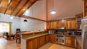 A spacious kitchen with wooden cabinets, granite countertops, and stainless steel appliances.