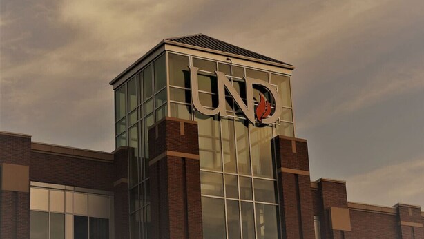 A modern building with a prominent 'UND' logo on the facade. - The Gateway: experience a stylish and welcoming lodging, perfect for groups. (Grand Forks)