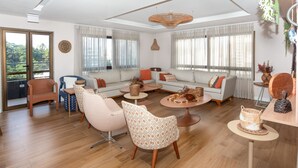 Un amplio salón con un conjunto de sofá, dos sillones, una mesa de centro y una mesita auxiliar.