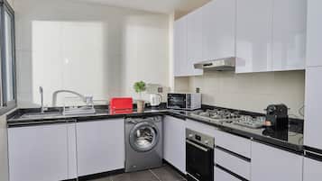 Apartamento Deluxe | Cocina privada | Frigorífico grande, microondas, horno y máquina de café espresso