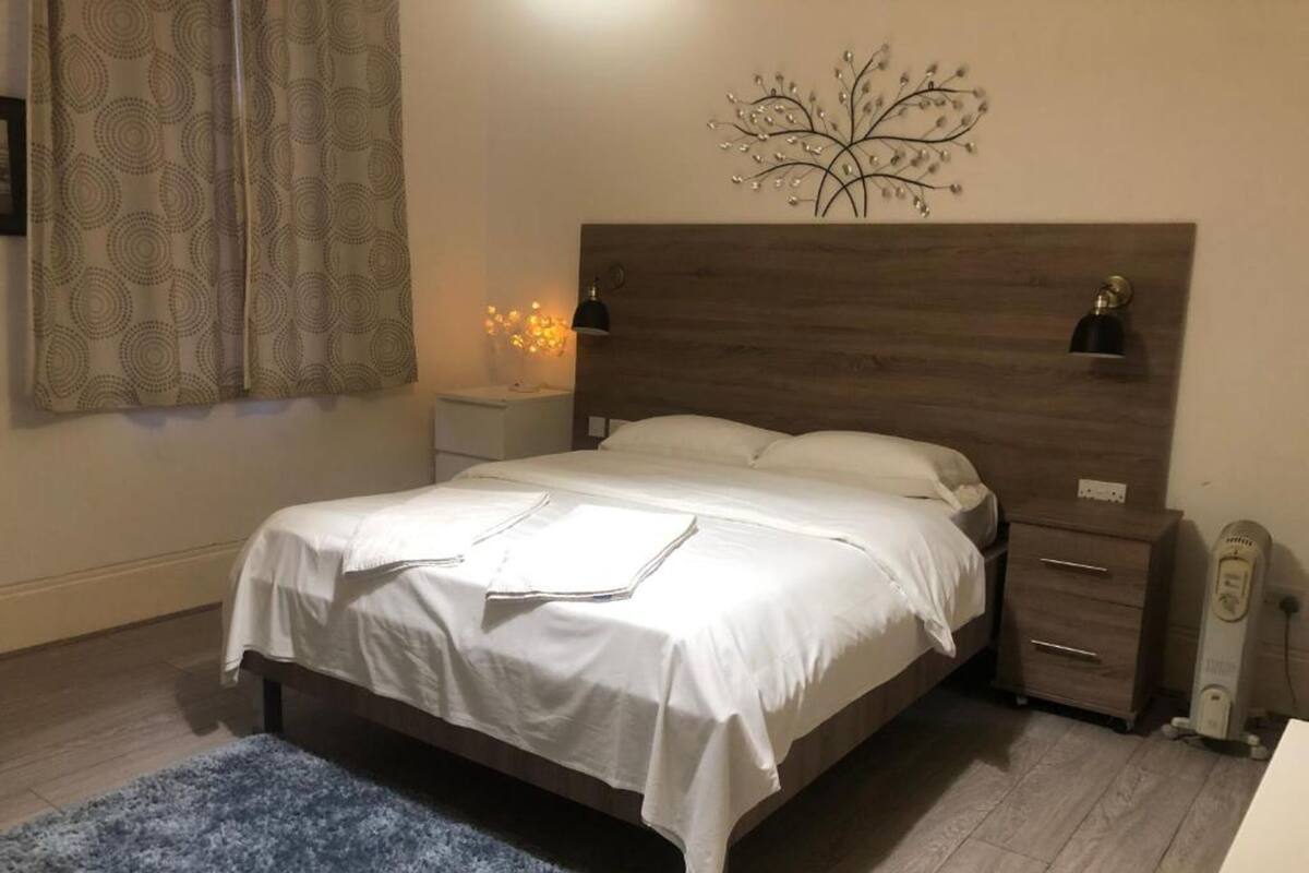 1 habitación, escritorio, tabla de planchar con plancha y ropa de cama