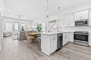 Enjoy cooking in this well-equipped kitchen with a dishwasher, microwave, and oven, and dining area with a table and comfortable seating.