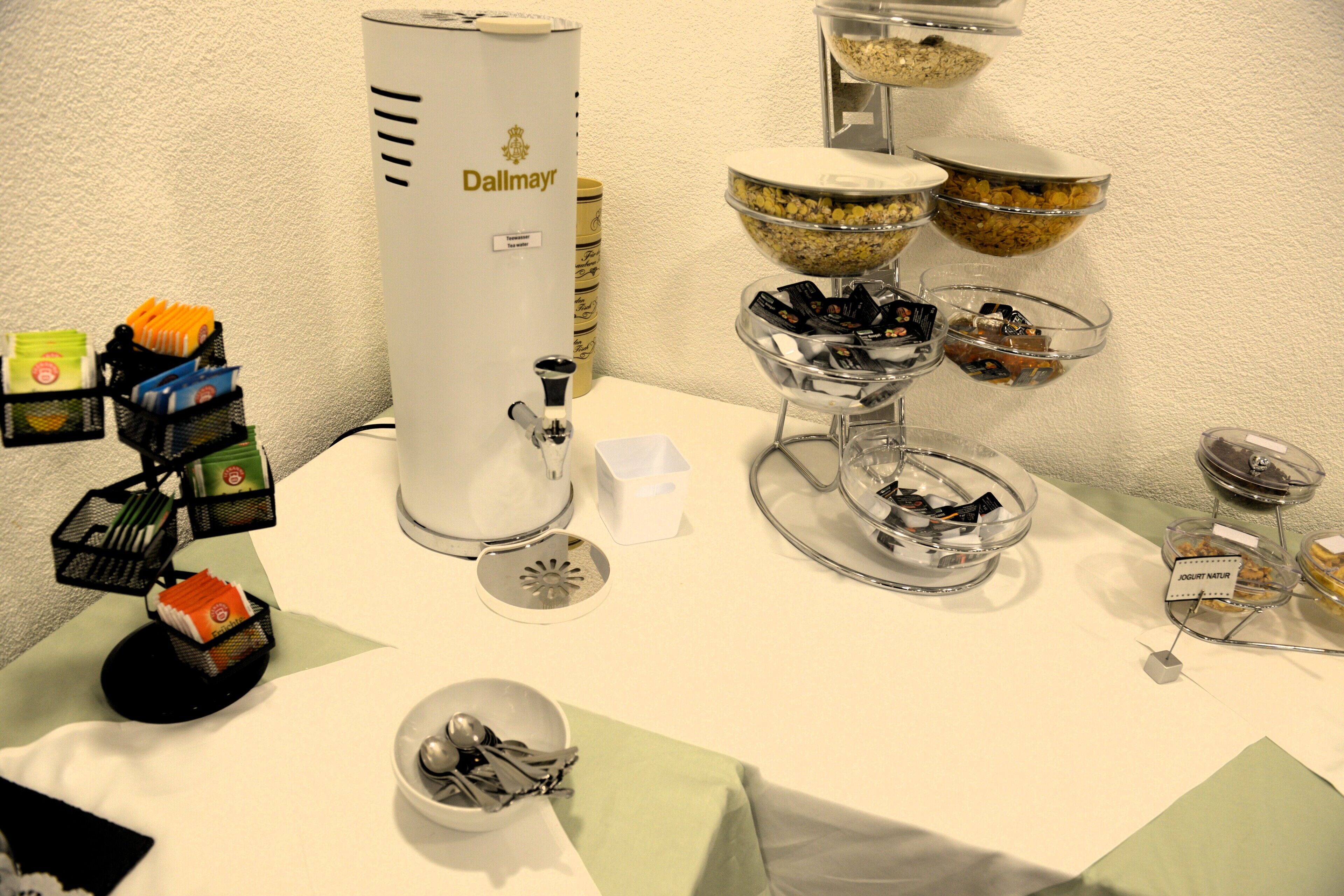 Montaje tipo buffet con diversos alimentos y una máquina de café.