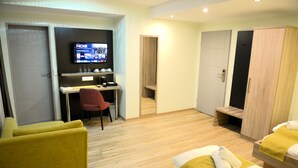 A hotel room with a bed, a desk with a chair, a TV, and a wardrobe. - Hotel zur Flüh, Self Check-in (Bad Saeckingen)