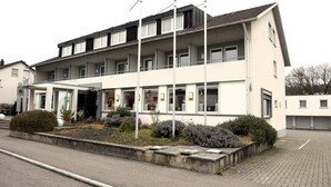 A multi-story building with a flat roof, large windows, and a covered entrance area. - Hotel zur Flüh, Self Check-in (Bad Saeckingen)