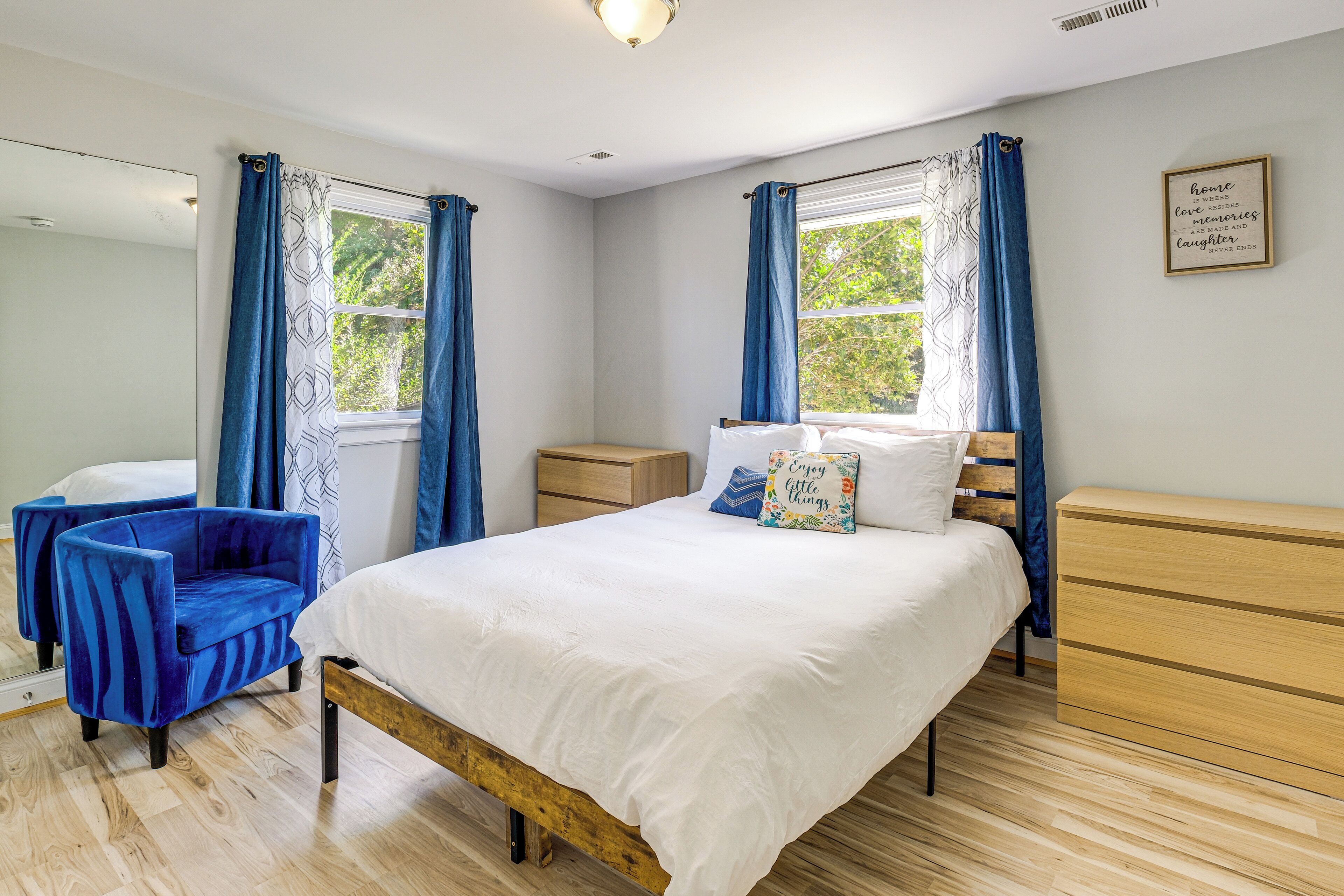 Un dormitorio con cama, una silla, una mesita de noche y un aparador.
