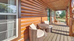 Eine Holzterrasse mit Korbmöbeln und Blick auf die Umgebung.