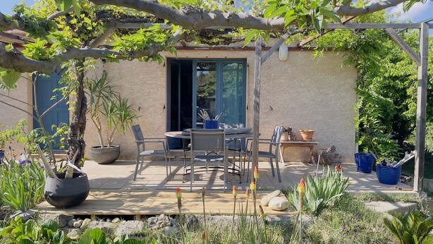 A patio area with a table and chairs, surrounded by potted plants and a pergola. - Villa with pool, conveniently located between Arles Nimes and Avignion (Comps)