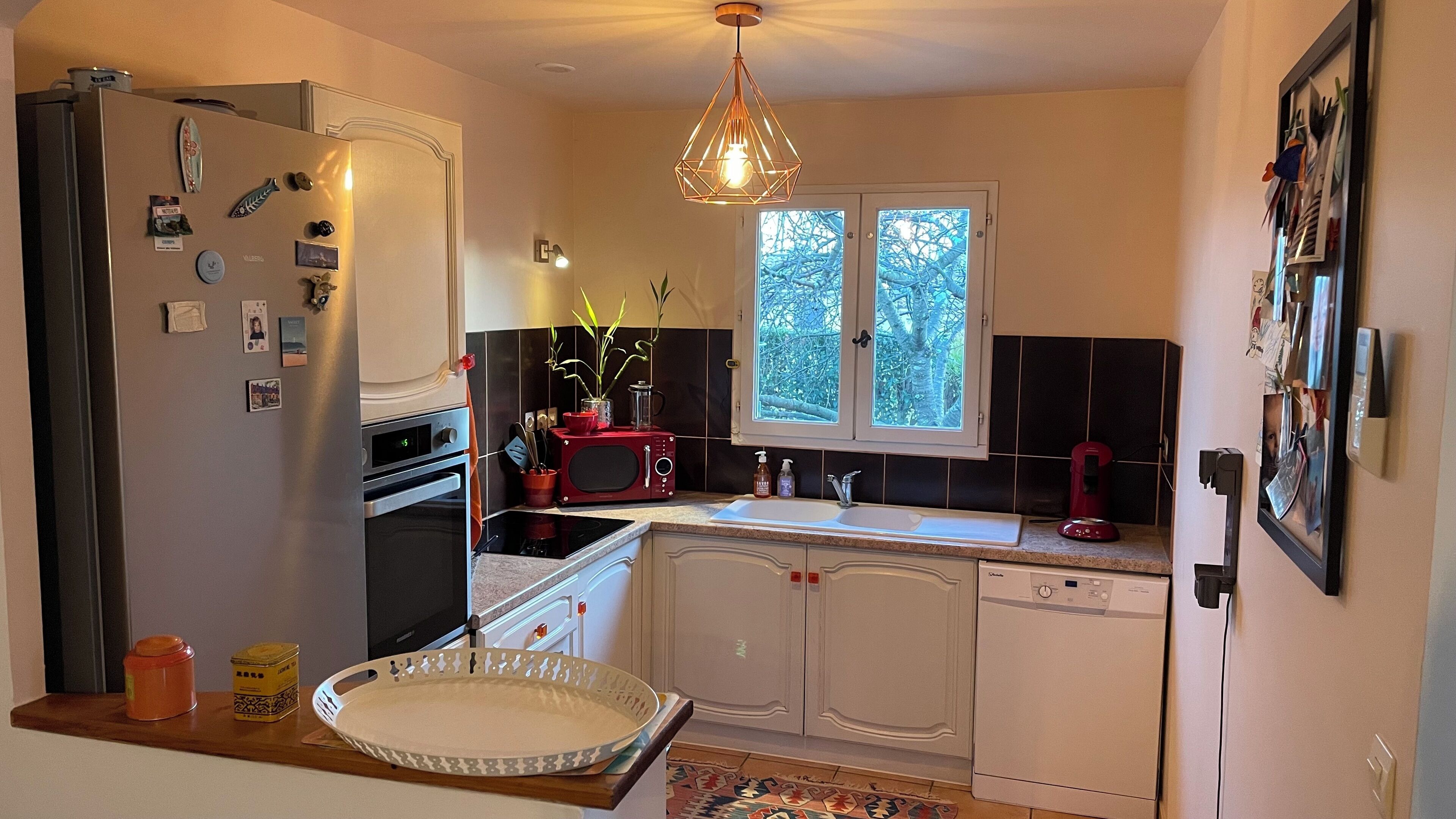 A compact kitchen with a refrigerator, oven, microwave, sink, and dishwasher.