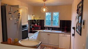 A compact kitchen with a refrigerator, oven, microwave, sink, and dishwasher. - Villa with pool, conveniently located between Arles Nimes and Avignion (Comps)