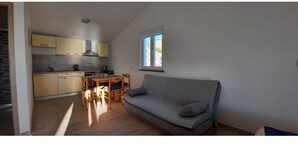 A compact living space with a kitchenette, a sofa, and a dining area. - Endless Horizont - Studio Apartment With Balcony (Razanac)