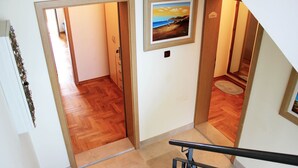 Eine Treppe mit hölzernem Geländer, einem Holzboden und einem Bild an der Wand.