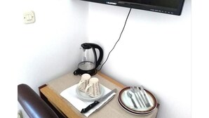 A small table with a coffee maker, two coffee cups, a plate with cutlery, and a TV mounted on the wall. - Ana Guest House - Double room with private terrace (Nin)