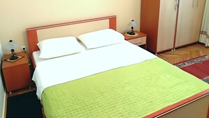 A hotel room with a bed, a nightstand with a lamp, a wardrobe, and a framed picture on the wall. - Ana Guest House - Double room with private terrace (Nin)