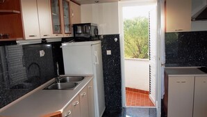 A kitchen with a sink, stove, and cabinets.