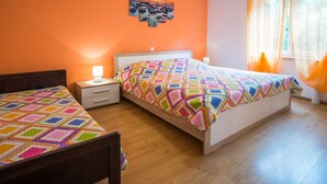 Ein Schlafzimmer mit zwei Betten, einem Nachttisch, einer Lampe und einem Bild an der Wand.