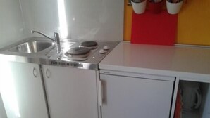 A compact kitchen with a sink, stove, and storage cabinets. - Katarina - Traditional Two Bedroom Apartment with Sea View (Razanac)