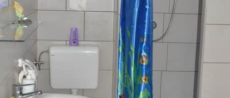 A bathroom with a white sink, toilet, and shower.