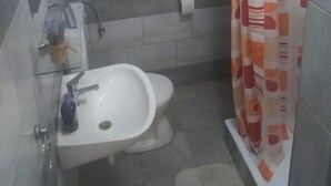 Un bagno piccolo con un lavandino bianco, un water e una tenda per la doccia.