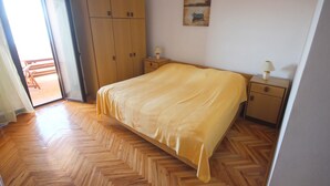 Ein Schlafzimmer mit einem Bett, einem Holzschrank, Nachttischen und einem Bild an der Wand.