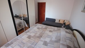A bedroom with a bed, a wardrobe, and a door. - Njaco - Three Bedroom Apartment with Sea View (Razanac)