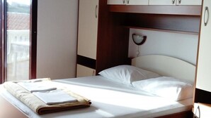 Een hotelkamer met een bed, nachtkastje, lamp en uitzicht.