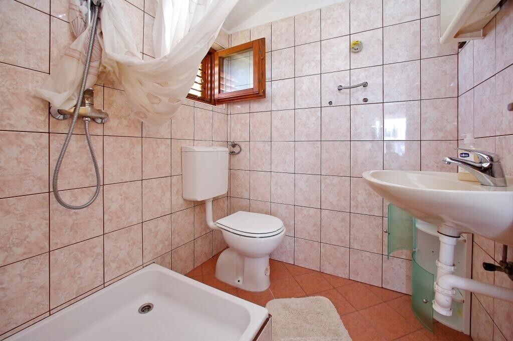 A bathroom with a bathtub, toilet, and sink.