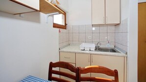 Una cocina compacta con pileta, alacenas y una pequeña mesa.