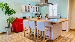 A modern kitchen with a central island, white cabinets, and a red appliance. - Chez Georges - House 3 - Lakes and Gorges du Verdon (ESPARRON DE VERDON)