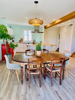 A modern kitchen with a round wooden table, white chairs, and a hanging light fixture. - Chez Georges - House 3 - Lakes and Gorges du Verdon (ESPARRON DE VERDON)