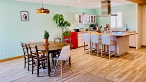 A modern kitchen with a central island, wooden flooring, and a dining area with a table and chairs. - Chez Georges - House 3 - Lakes and Gorges du Verdon (ESPARRON DE VERDON)