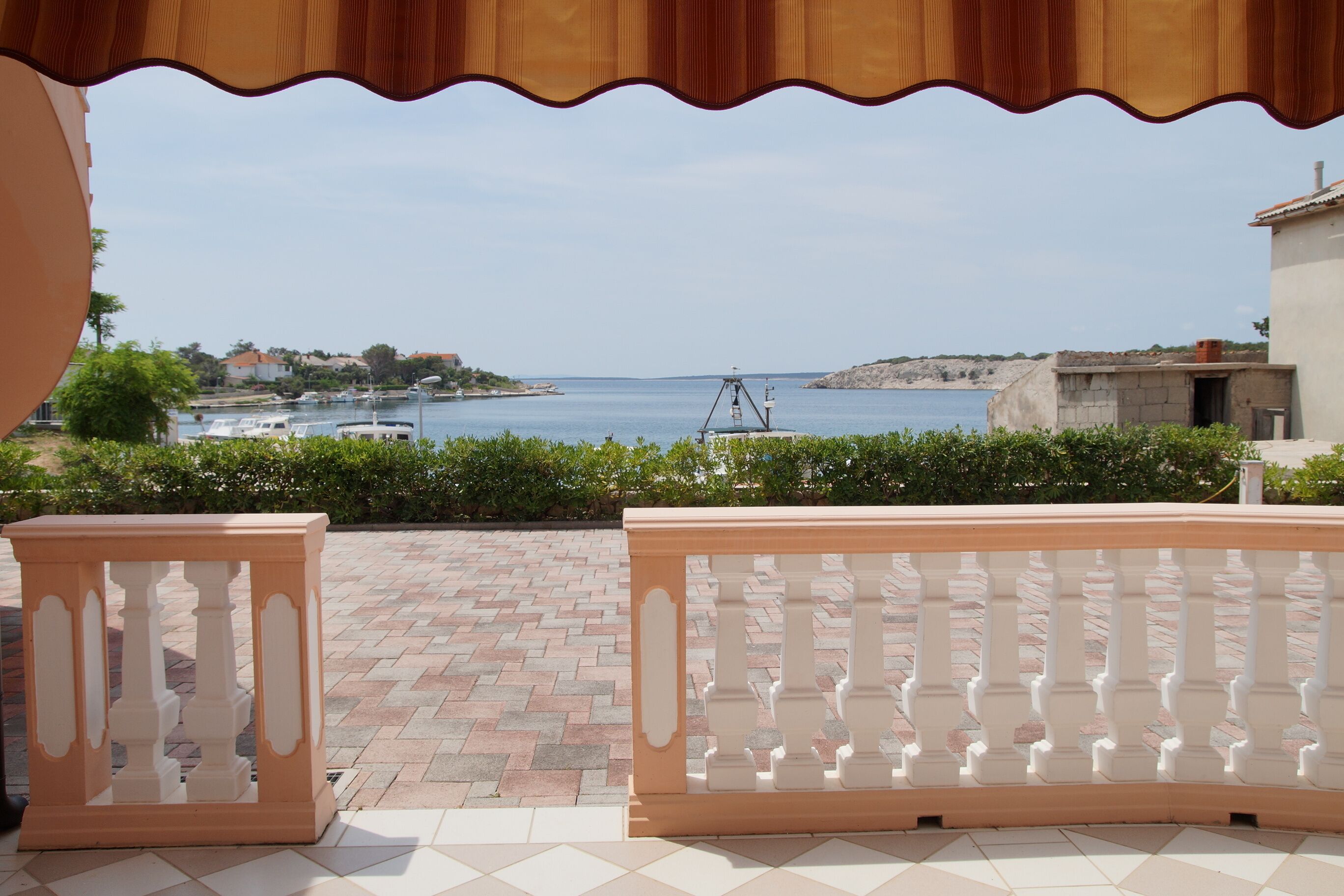 Un balcon avec vue sur la mer, un sol carrelé et une balustrade.