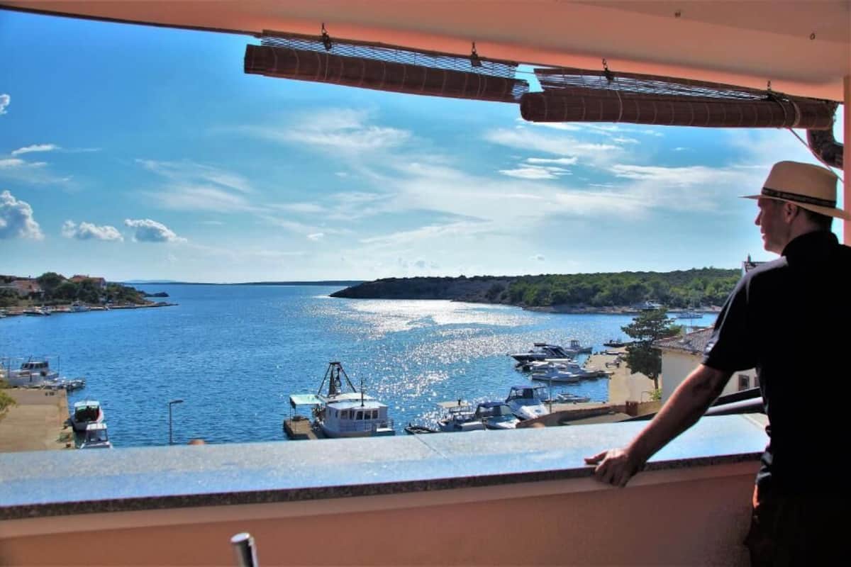 A balcony overlooking a marina with boats and a clear view of the water.