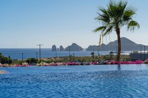 Uma piscina com vista para o oceano e montanhas.