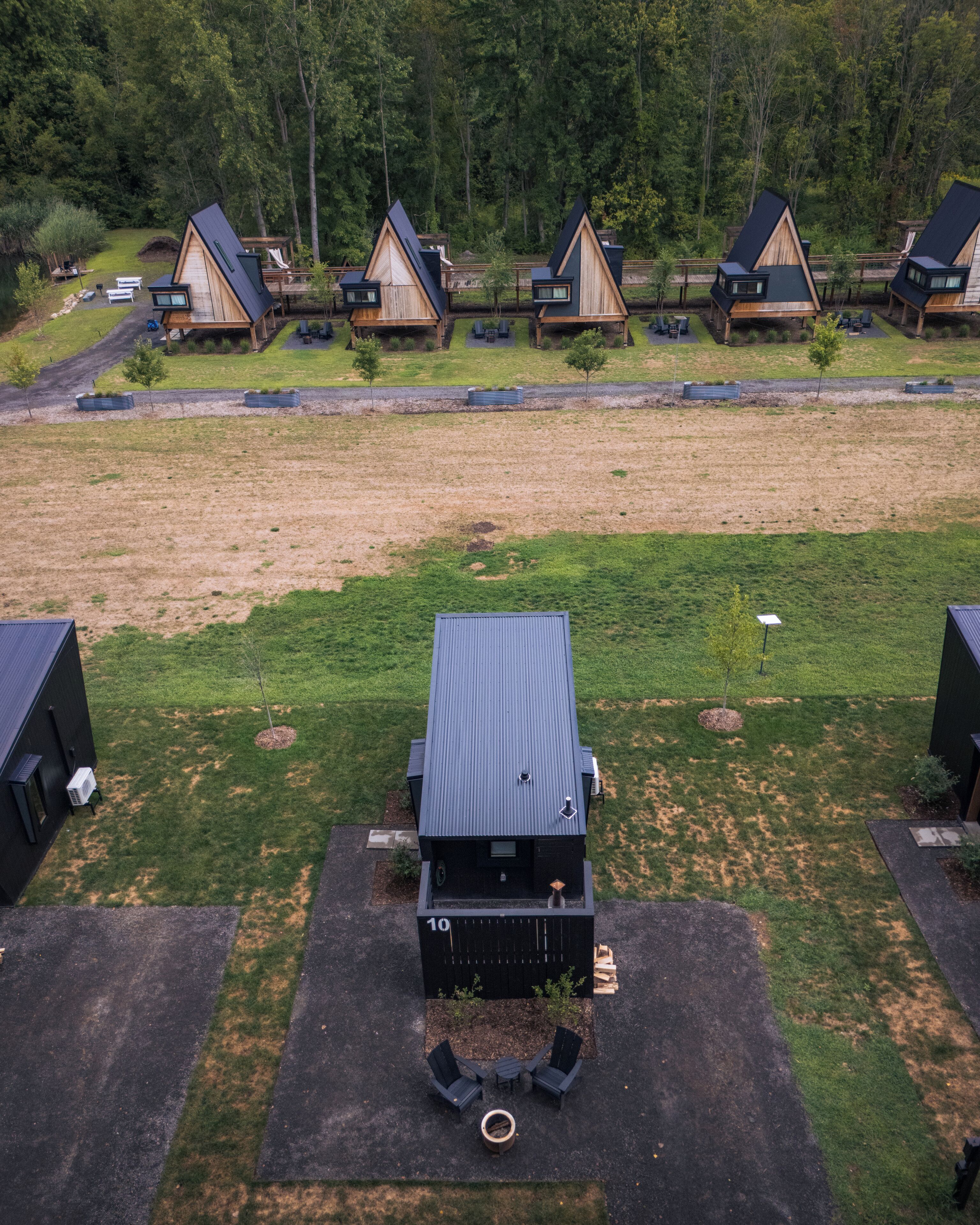A row of cabins with a central building, each with a sloped roof and a small deck area.