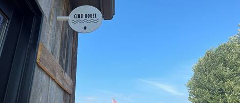 Een 'CLUB HOUSE' bord aan de buitenkant van een gebouw.