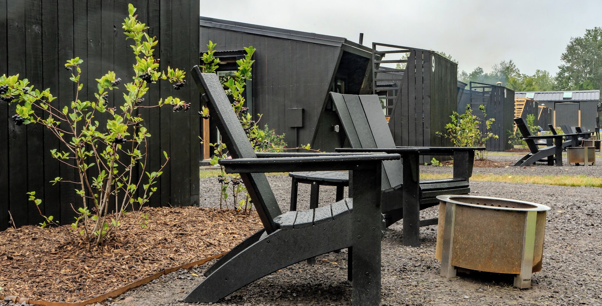 A rustic outdoor seating area with a metal bench and a metal planter.