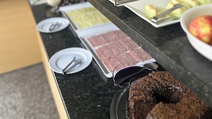Una mesa de buffet con diversos alimentos y un espejo en la pared.