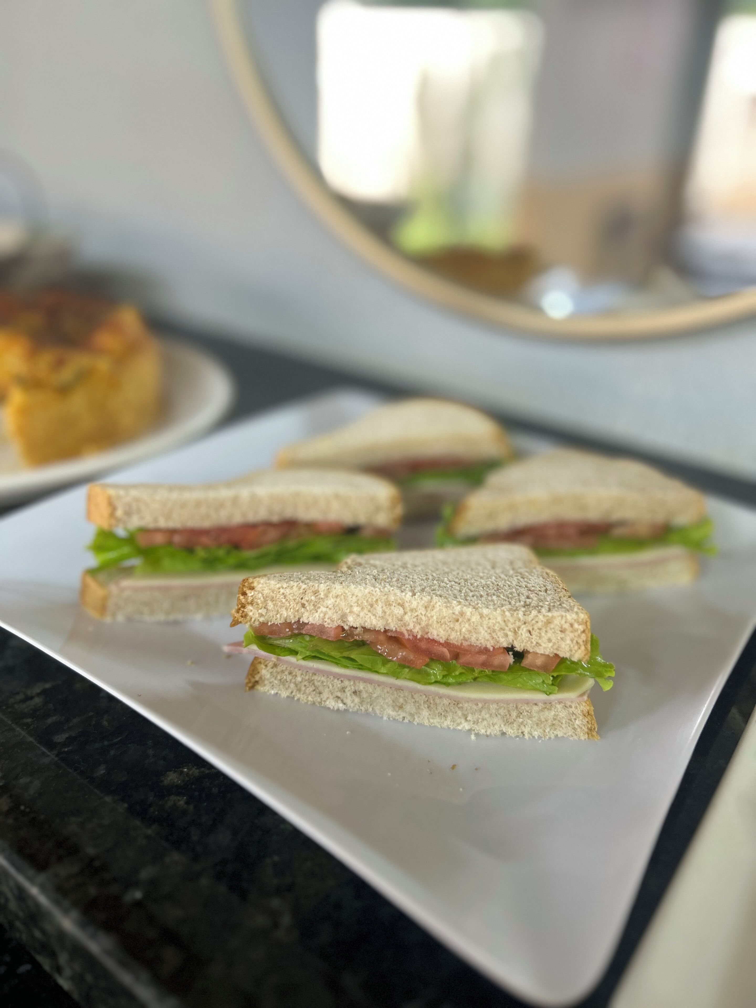 Un plato con varios sándwiches sobre una encimera de mármol.
