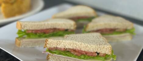 Un plato con varios sándwiches sobre una encimera de mármol.