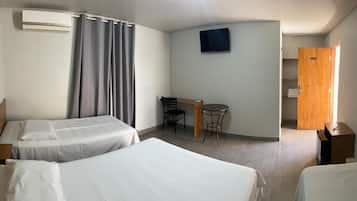 Una camera d'albergo con due letti, una scrivania con una sedia, una televisione e un armadio.