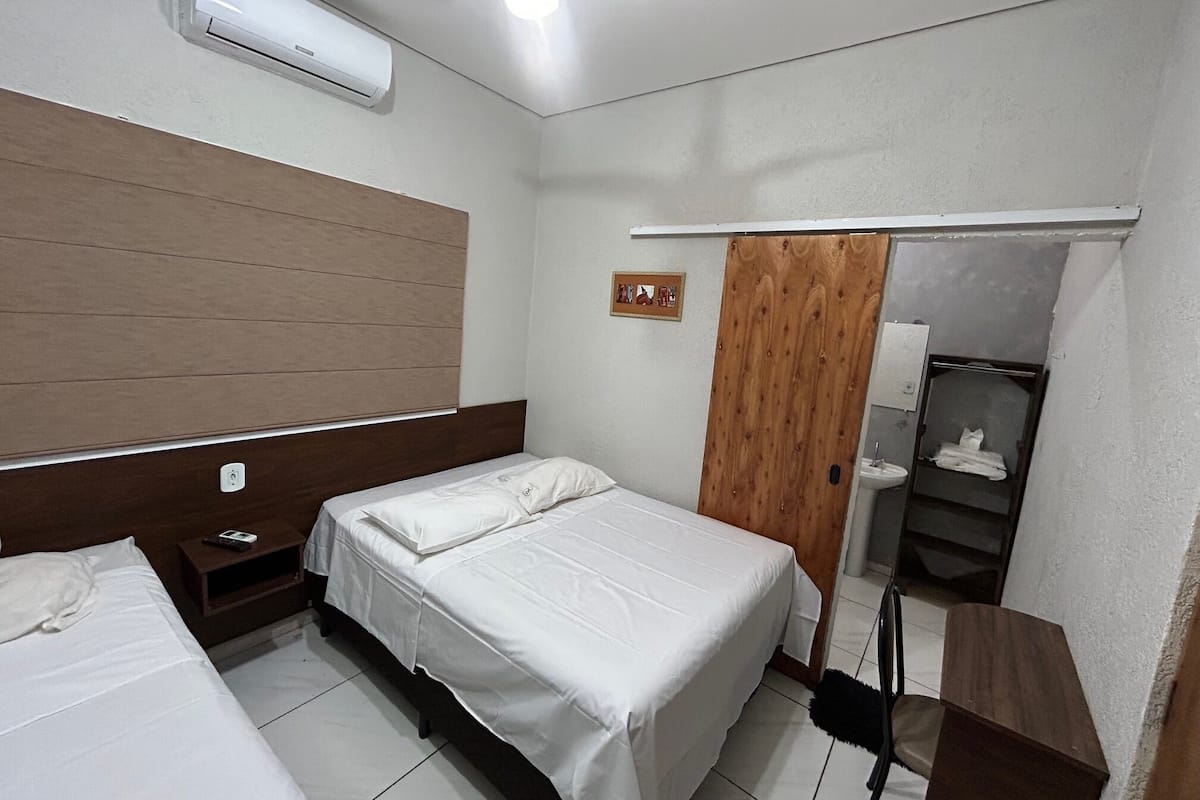 Een slaapkamer met een bed, nachtkastje en een kledingkast.